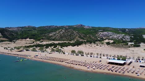 tsambika beach in faliraki, rhodes in greece filmed with the drone from above with mediterranean sea in the summer holiday