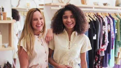 Retrato-De-Dos-Amigas-Divirtiéndose-Juntas-Comprando-Ropa-En-Una-Tienda