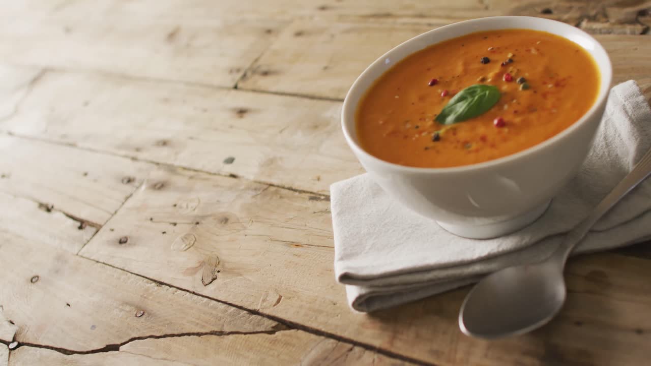 video de sopa de tomate con crema en un cuenco en una mesa de madera