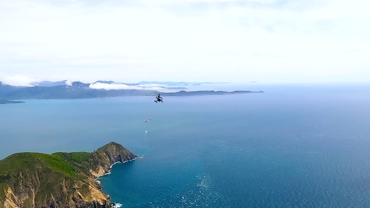 Helicopter flying high over the rocky islands of the Marlborough sounds towards the west, New Zealand