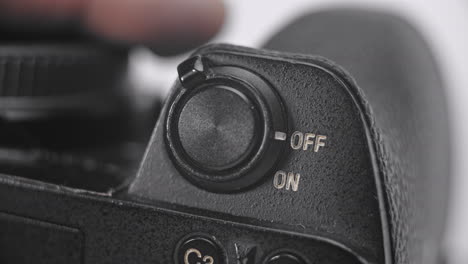 a close-up shot of a cameras on off toggle switch being flicked