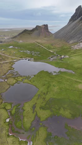 aldea vikinga y sus alrededores enclavada entre las montañas y humedales de islandia en una toma vertical aérea