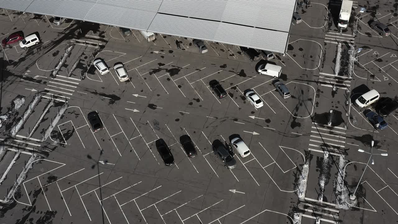 자동차는 빈 주차장을 통과하여 많은 빈 주차 공간을 가지고 있습니다. - 공중 드론 촬영