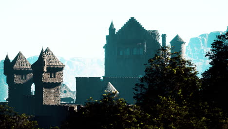 una silueta de un castillo en ruinas contra una cordillera