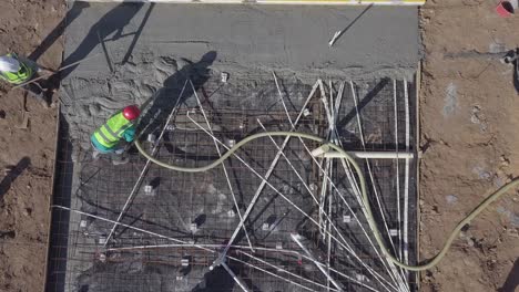 Vertical-aerial-view-of-construction-workers-pouring-new-concrete-floor
