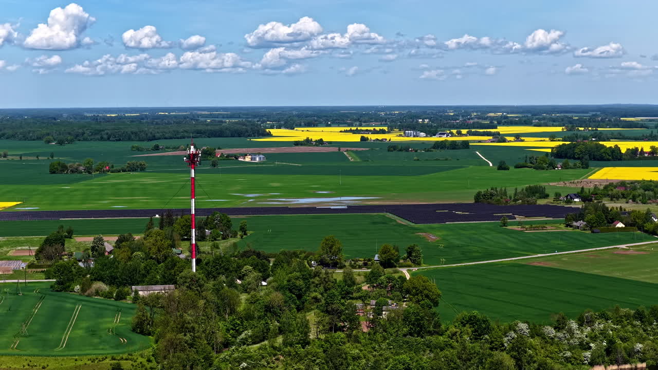 Green farmlands with rapeseed and 5G tower, aerial view