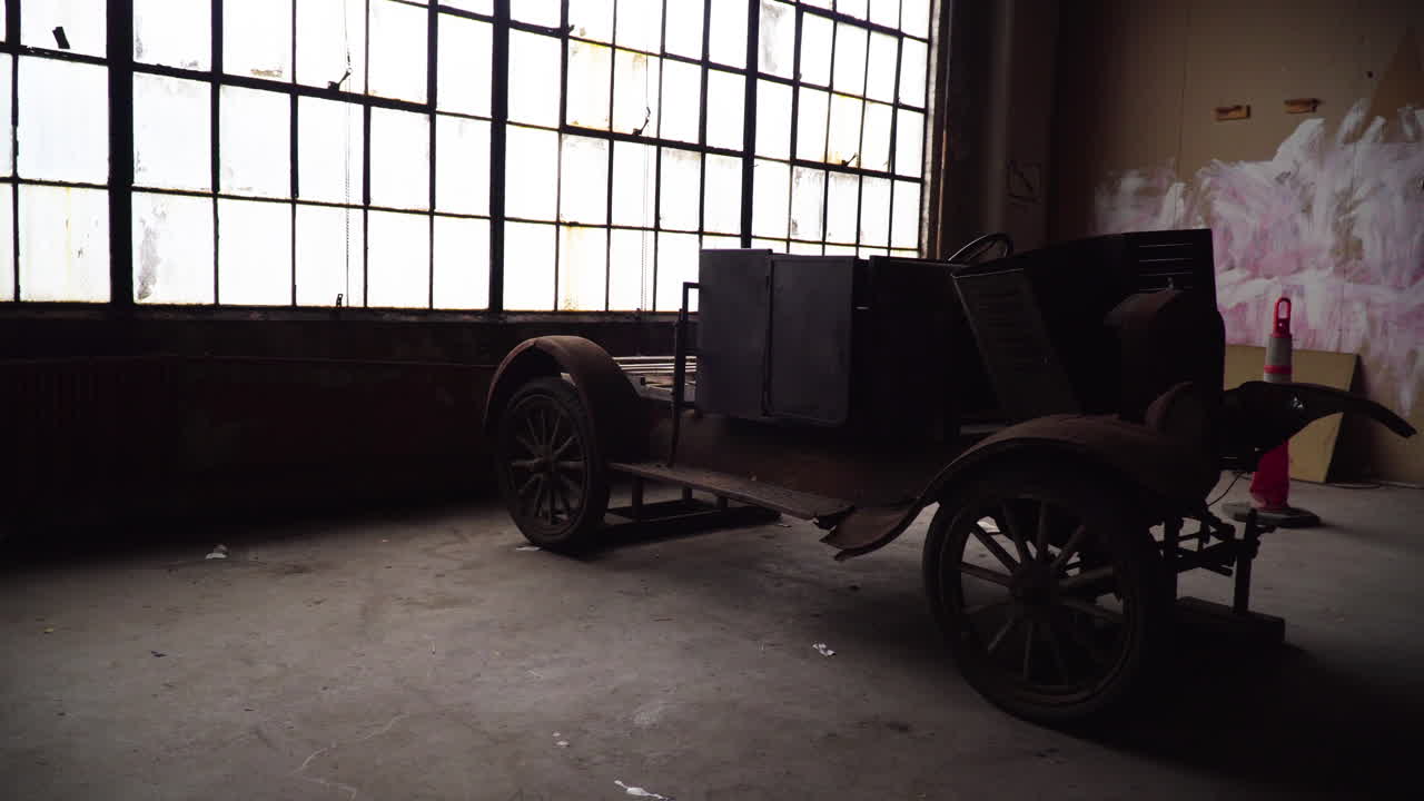 Rusty car in an abandoned warehouse next to stained glass