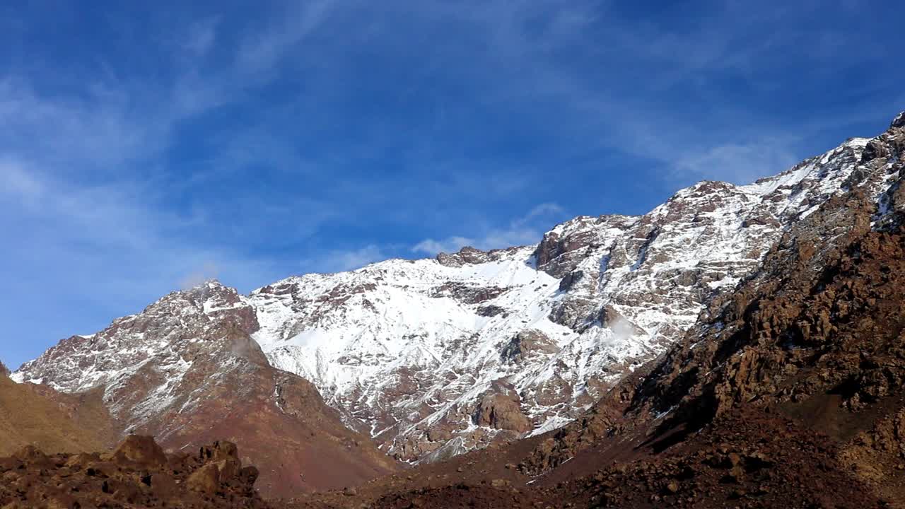 clouds dance around snow capped high atlas mountains morocco