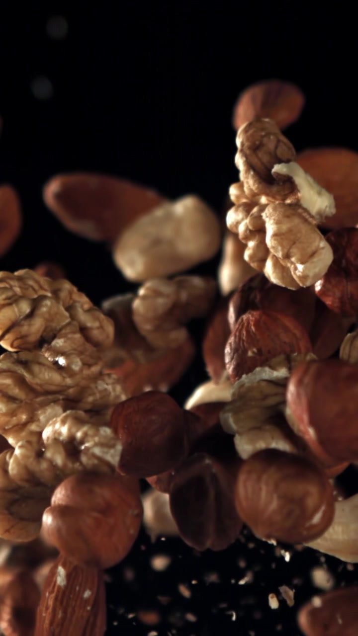 Healthy Mixed Nuts Falling in Slow Motion Against a Dark Background
