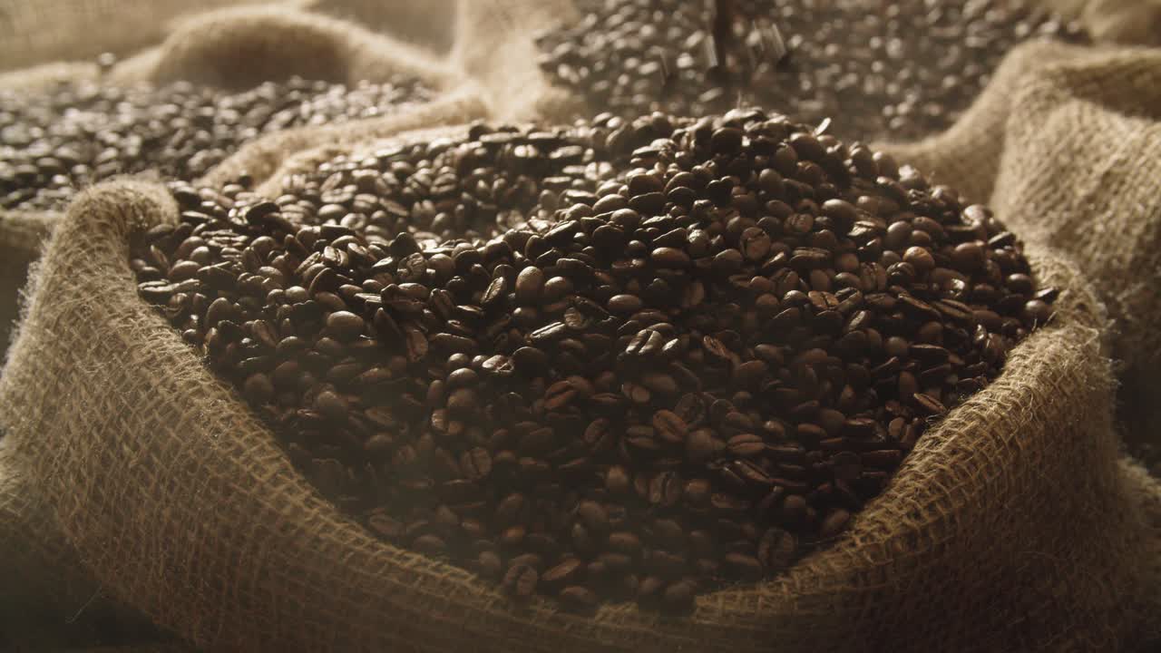 Medium close up slow motion footage of hand scooping up steaming roasted coffee beans from linen bag