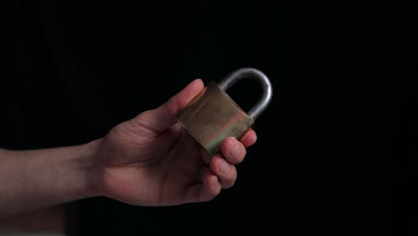 close up of hands opening a yellow padlock with key