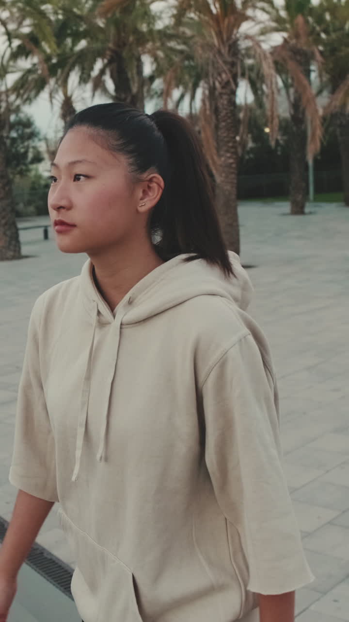 Asian woman in hoodie outdoors