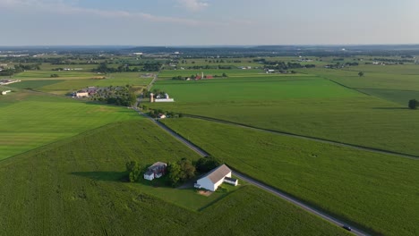 a rural farmhouse and barn sit beside a long, winding road in pennsylvania