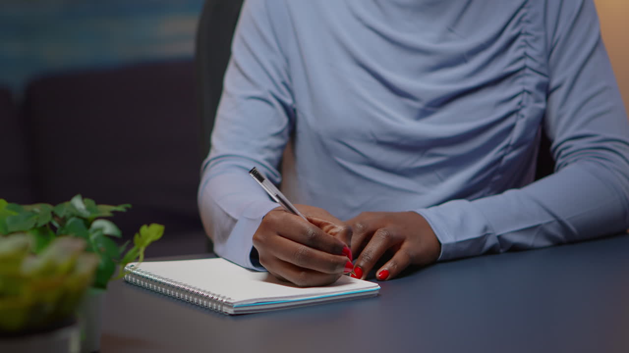 Close up of african businesswoman writing list of tasks