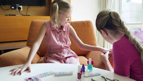 madre e hija haciendo arte de uñas en casa