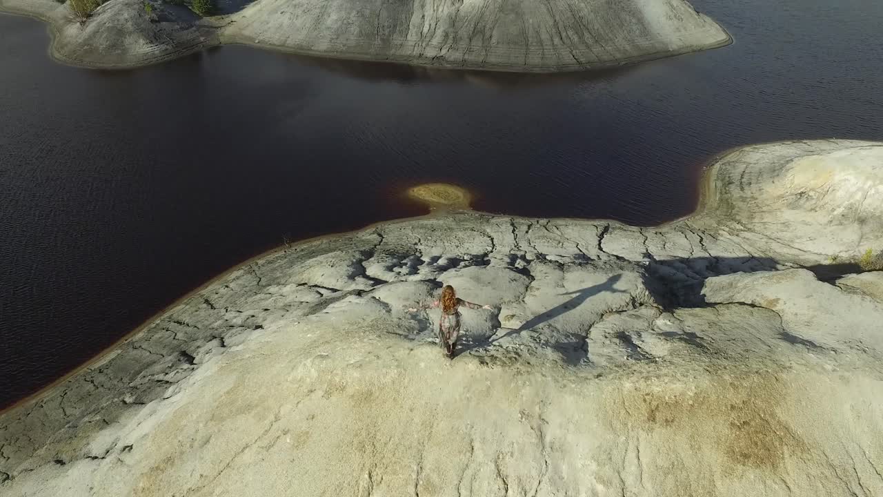 mujer vestida en la parte superior de un paisaje de cantera