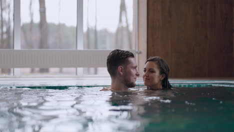 man and woman are swimming together in swimming pool of modern thermal bath relax and rest in weekend