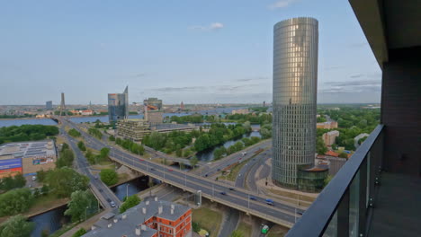 high angle shot from a balcony of road network running alongside tall office buildings in riga, latvia during morning time