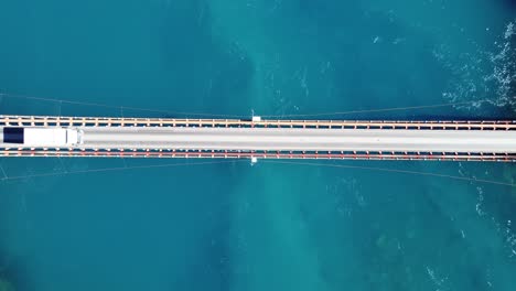 aerial top down view of truck driving crossing over bridge