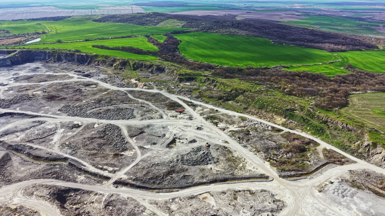 Granit ocağı alanı, yeşil tarlaların ve kıvrımlı nehir manzarasının yakınında aktif taş çıkarımını gösteriyor.
