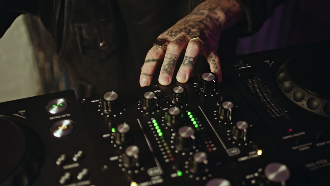 DJ hands controlling equipment at club party making rhythmic performance closeup