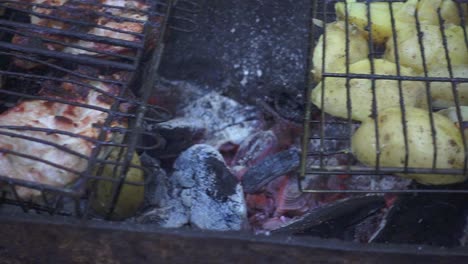 fresh potatoes cooking on barbeque grill on summer picnic at nature
