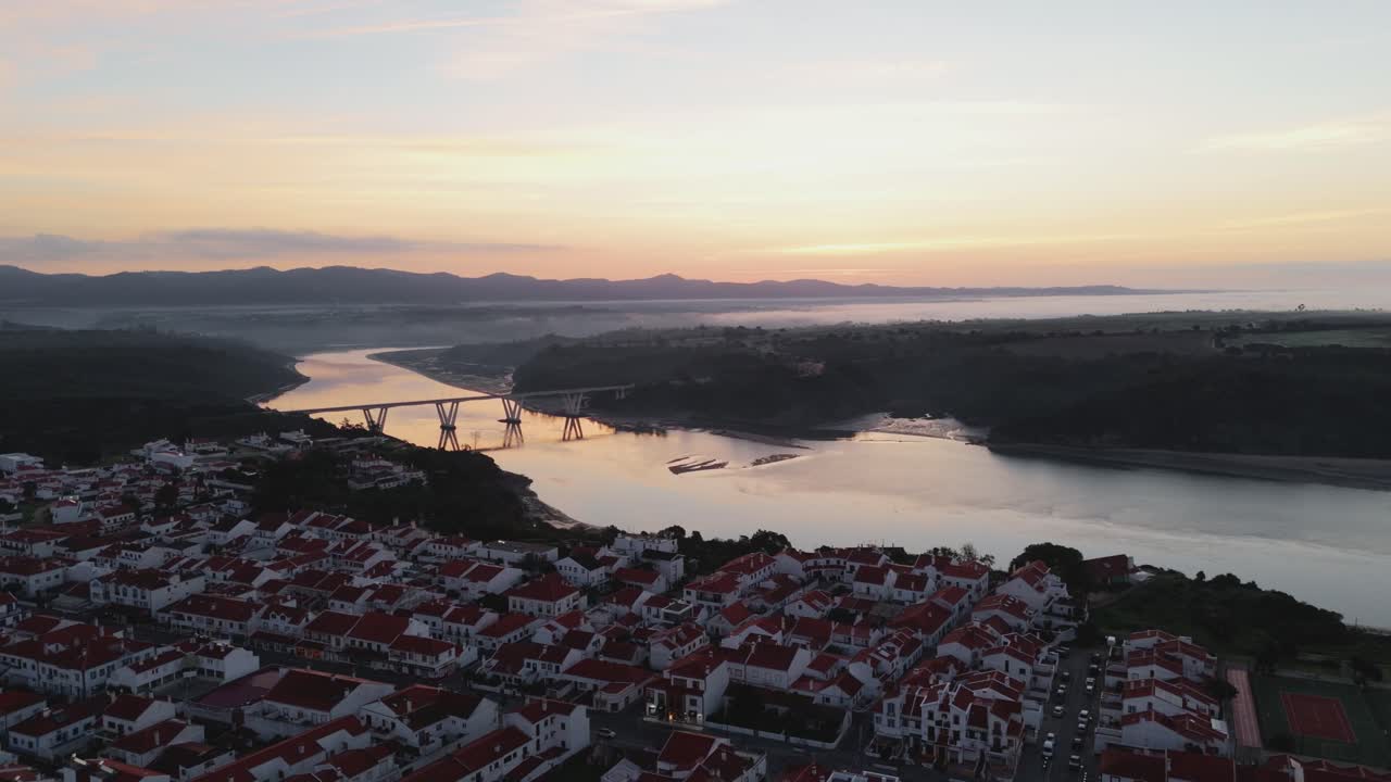 포르투갈 알렌테조 주 빌라 노바 데 밀폰테스 시에 있는 미라 강을 가로지르는 도로 다리의 해가 뜨는 모습