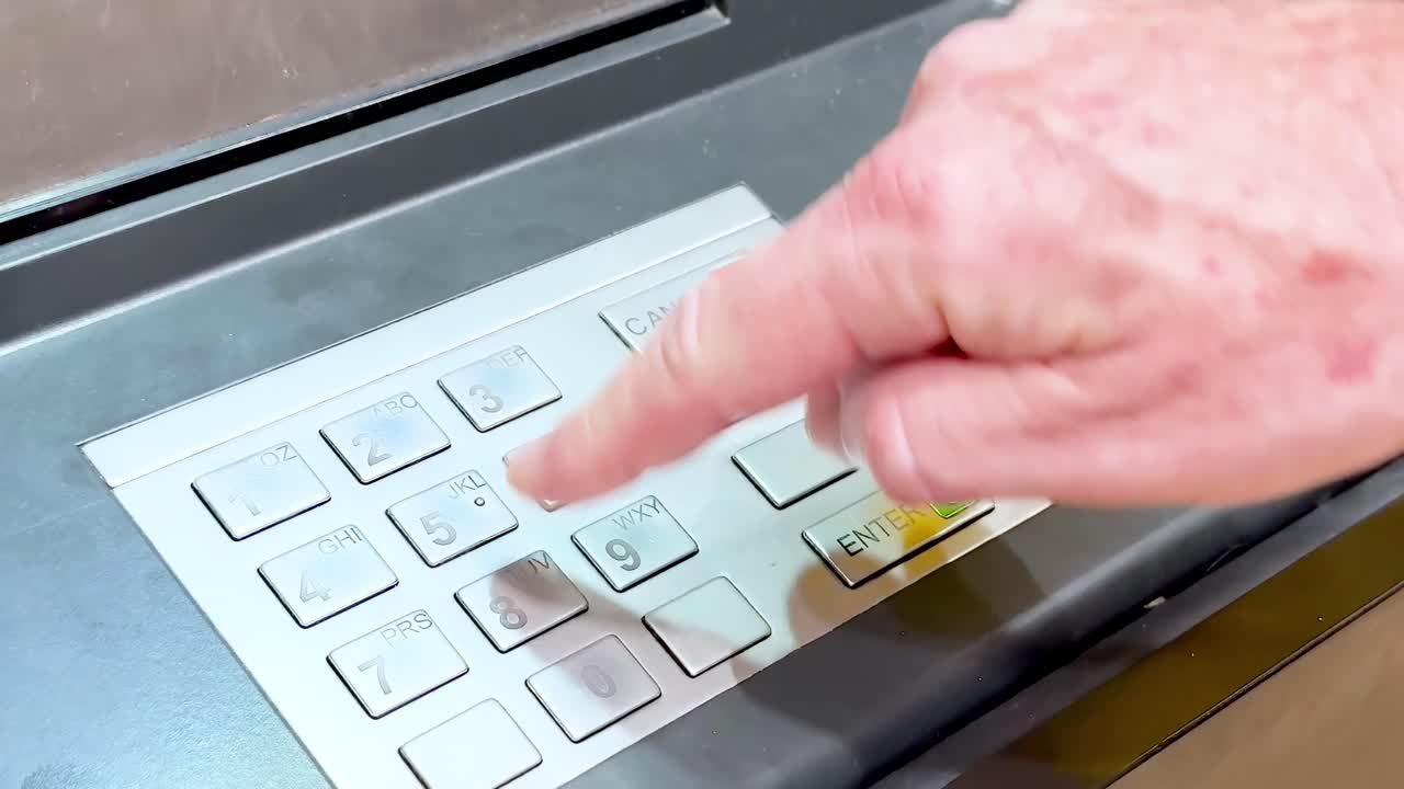 Hand interacting with ATM keypad