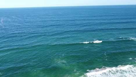 Drone-Volando-Hacia-El-Mar,-Olas-Rompiendo-Debajo