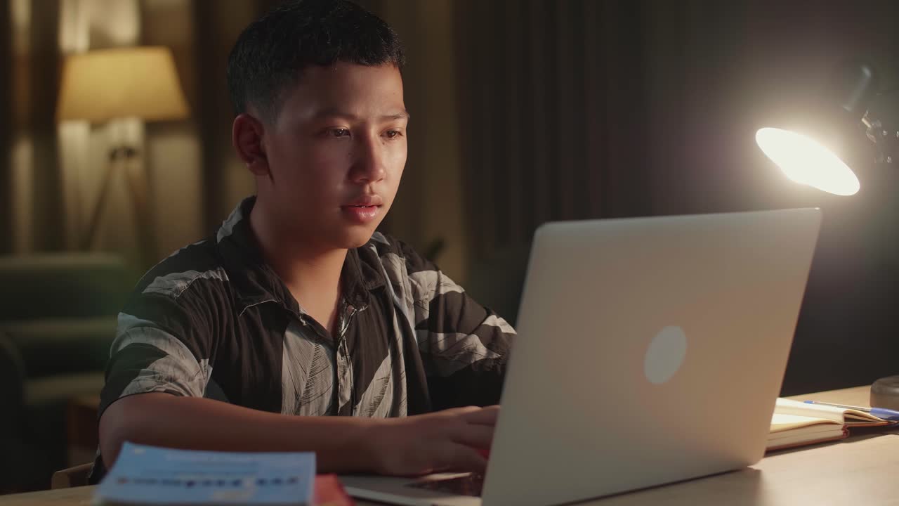 Teenager Studying on Laptop at Night