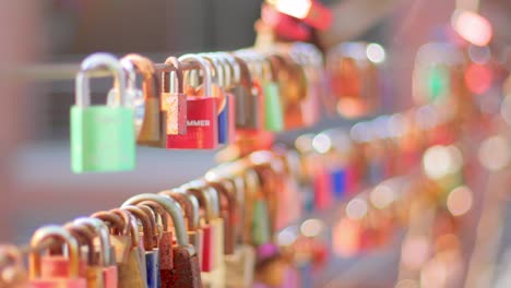 Close-up-of-a-group-of-padlocks,-hanging-on-a-steel-cable