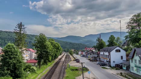 Train-Tracks-and-Street-View-Timelapse-in-Yaremche,-Ukraine-with-Clouds-and-Mountains