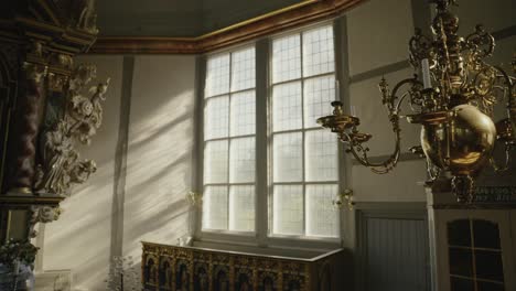 Golden-Chandelier-hanging-in-a-church-with-beautyful-sunlight