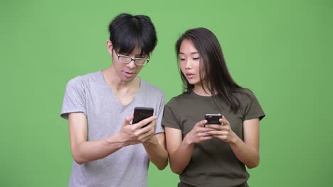 young asian couple using phone together