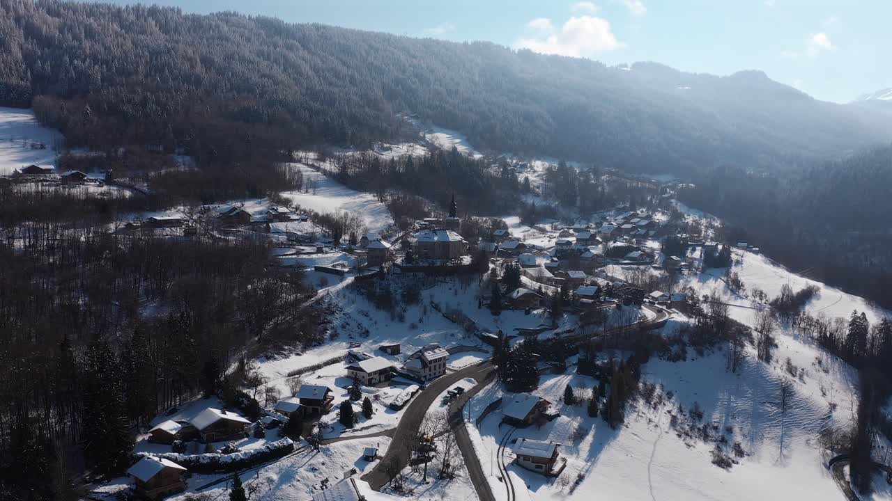 Drone shot of Saint Sigismond, blue sky, snow covered mountain, push in