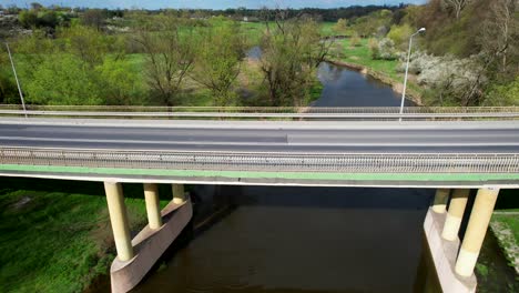 Aerial-View,-Slow-Camera-Movement-Forward,-Old-Bridge,-Łęczna,-Poland,-Cars,-River,-Nature,-Sunny-Day