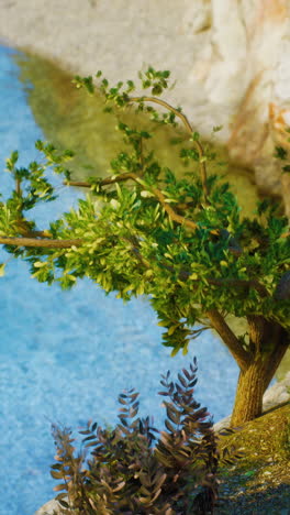 a green tree next to a blue river
