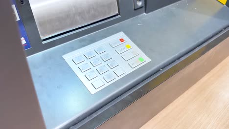 mano interactuando con el teclado del cajero automático en secuencia