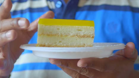 young men hand pick a cream cake on a plate