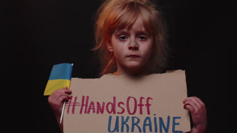 Scared-poor-girl-homeless-protesting-war-conflict-raises-banner-with-inscription-Hands-Off-Ukraine