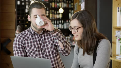 una pareja joven colabora en una computadora portátil