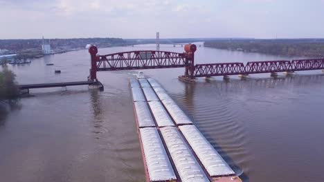 a beautiful aerial of a barge traveling under a steel drawbridge on the mississippi river 1