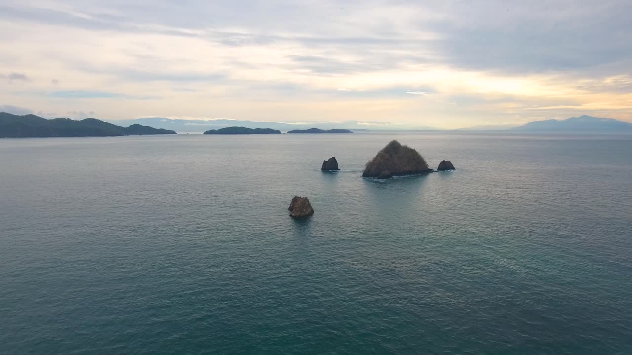 중앙아메리카의 열대 제도에서 바다에서 어나오는 작은 바위 섬들을 날아다니고 있습니다.