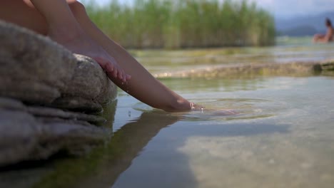 dipping feet in lake water puddle on a hot summer day, on jamaica beach, sirmione, lago garda, lake garda, italy