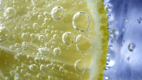 macro close up slice lemon, ice cubes and bubble float soda water.