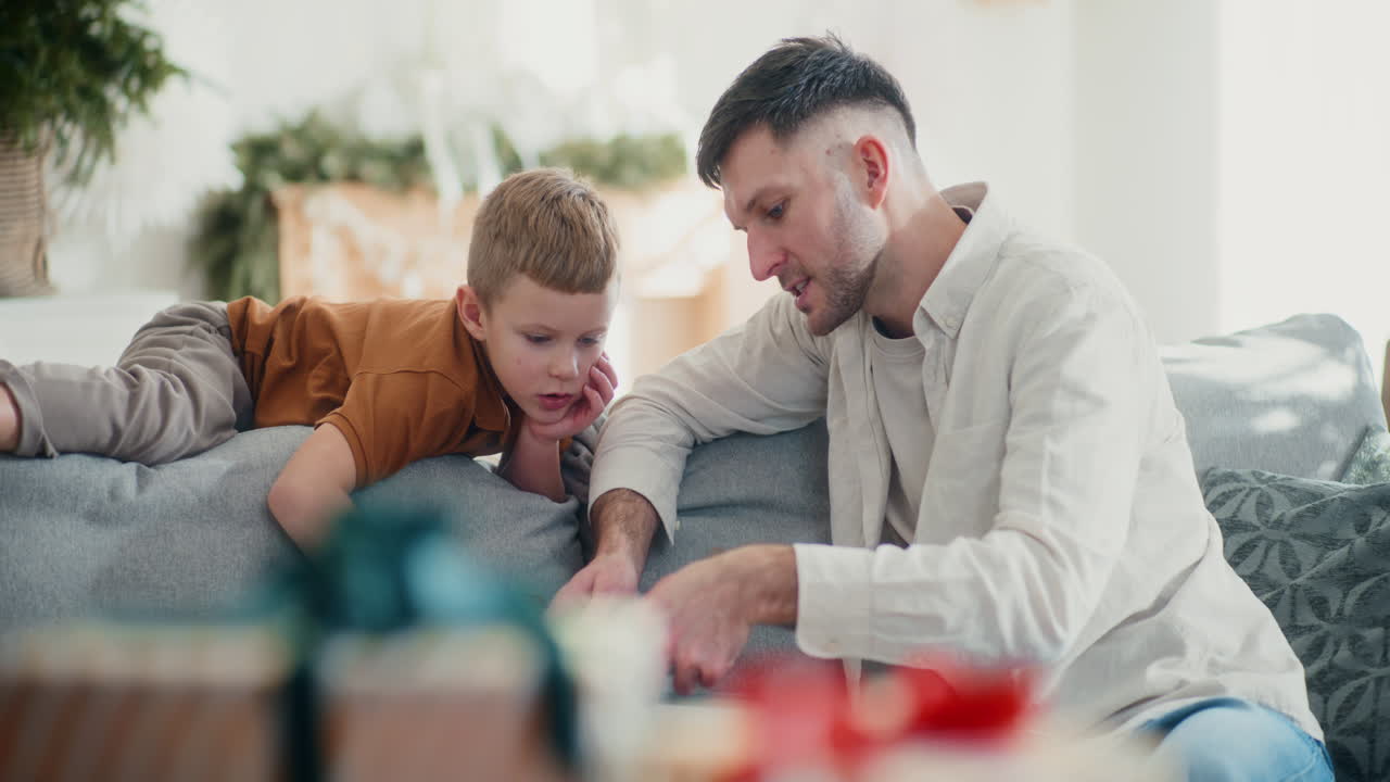 papá y su hijo pequeño desempaquetan las decoraciones de navidad y se preparan para la navidad