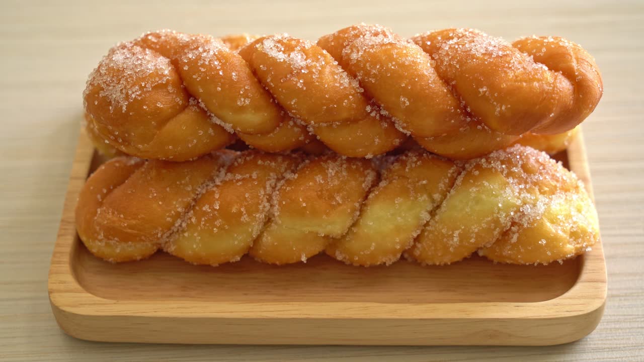 Donut de azúcar en forma de espiral sobre placa de madera