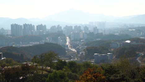 Edificios-De-Gran-Altura-Y-Con-Vehículos-Circulando-Por-La-Carretera-En-La-Ciudad-De-Chuncheon-Desde-Una-Montaña-En-La-Provincia-De-Gangwon,-Corea-Del-Sur