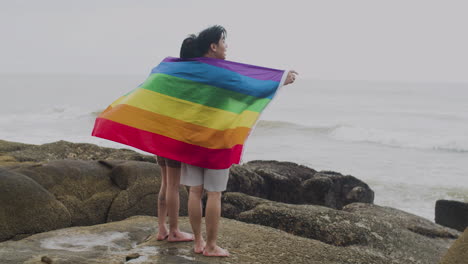 una pareja con una bandera arco iris.