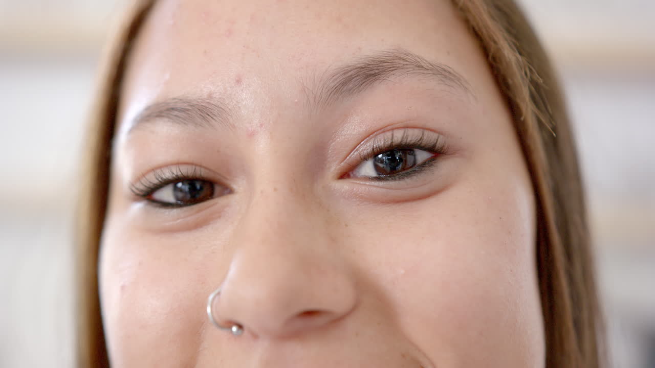 Close-up of young asian woman smiling with nose piercing and natural makeup